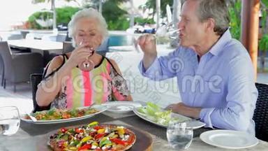 高级夫妇在户外餐厅享用美食